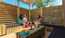 Des amis prennent l'apéritifs sur la terrasse d'un mobil home haut de gamme au cap ferret